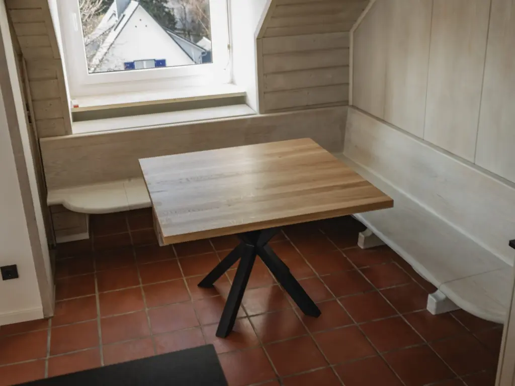 Essecke mit Eckbank und Holztisch unter der Dachschräge