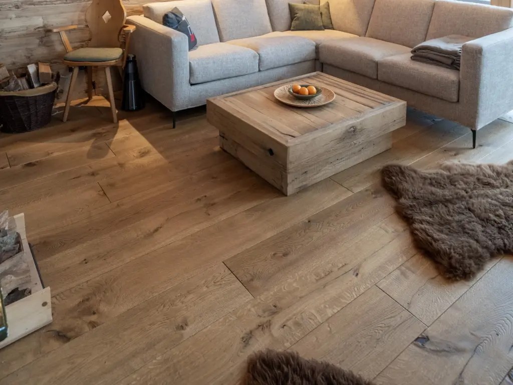Wohnzimmer mit Ecksofa, Holztisch und geöltem Eichenboden