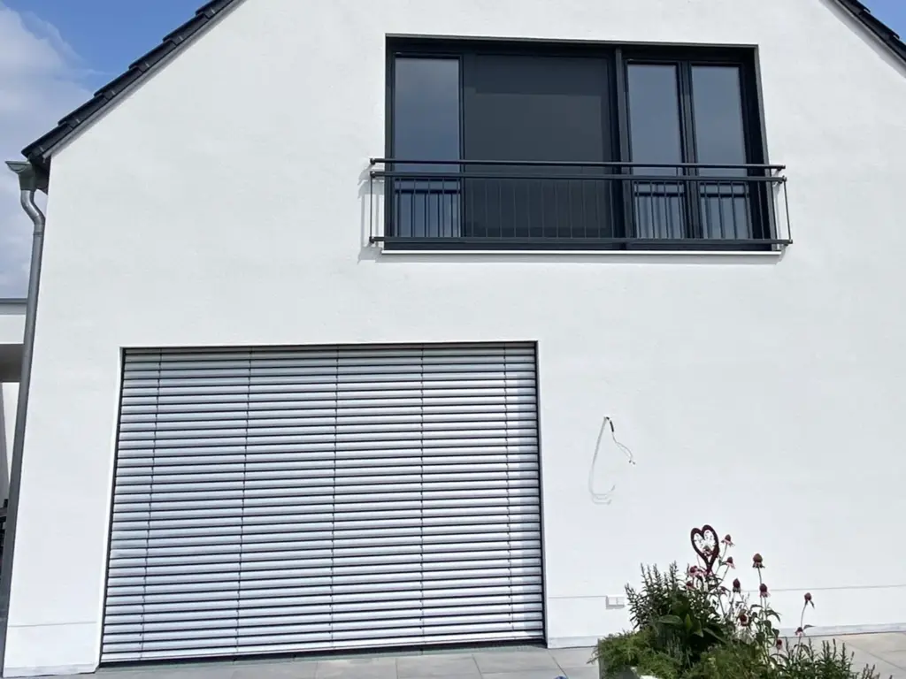 Einfamilienhaus mit anthrazitfarbenem Fenster, Balkongitter und Raffstore