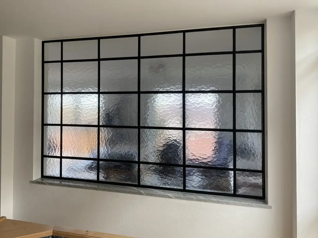 Innenfenster mit schwarzen Sprossen und Ornamentglas
