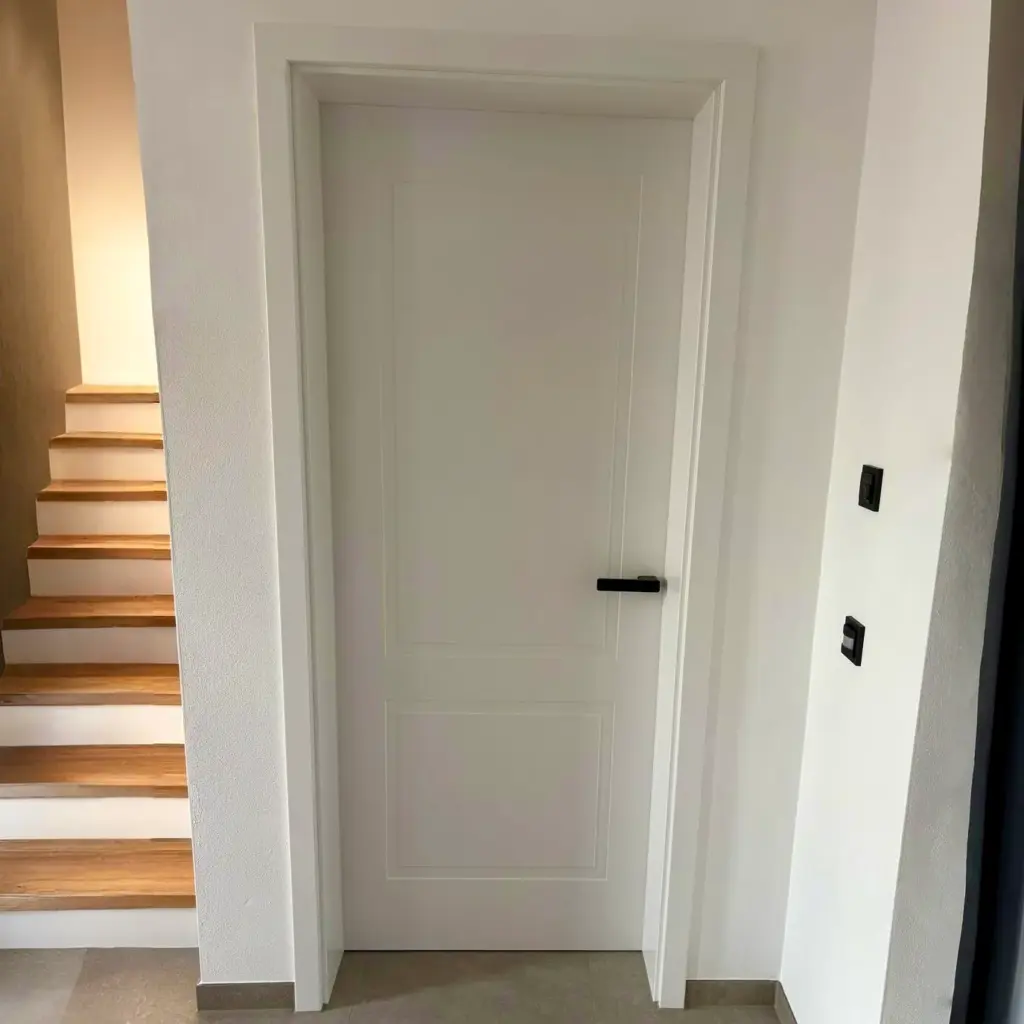 Weiße Zimmertür neben einer Holztreppe
